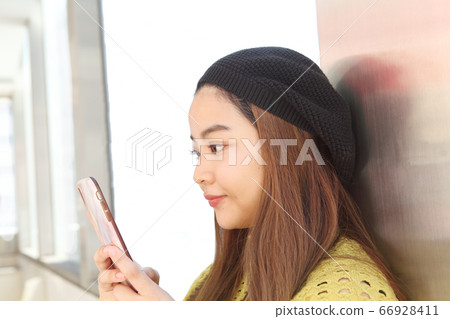 A young lady watching mobile A young lady watching mobile 66928411