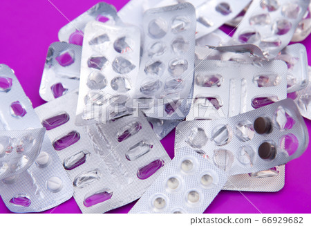 Many plastic pharmaceutical packaging for tablets and medicines drugs on the purple background Many plastic pharmaceutical packaging for tablets and medicines drugs on the purple background 66929682