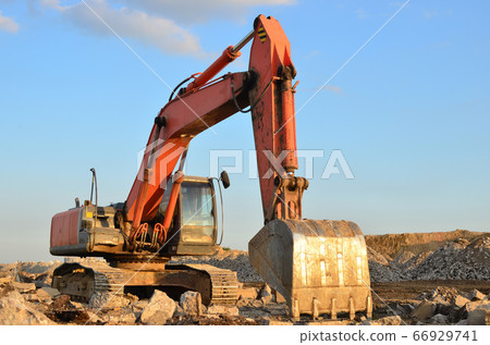 Excavator at construction site or mining quarry for crushing old concrete into gravel 66929741