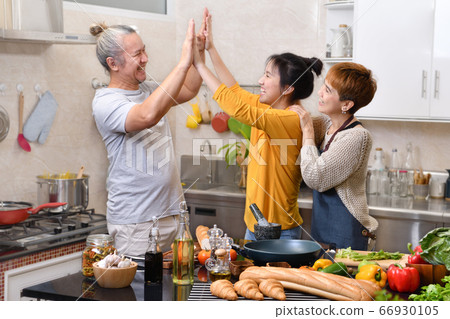 Happy family of mother father and daughter cooking in kitchen 66930105