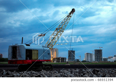 Large crawler crane or dragline excavator with a heavy metal wrecking ball on a steel cable 66931394