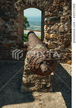 Old rusty iron cannon aiming through window at Marvao Old rusty iron cannon aiming through window at Marvao 66931988