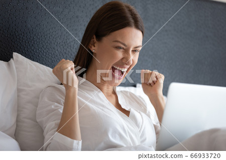 Excited woman scream winning lottery on laptop Excited woman scream winning lottery on laptop 66933720