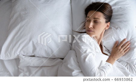 Sad young woman lying in bed feeling lonely Sad young woman lying in bed feeling lonely 66933862