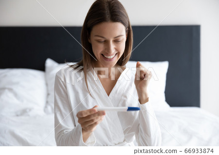 Overjoyed woman celebrate positive pregnancy test results Overjoyed woman celebrate positive pregnancy test results 66933874