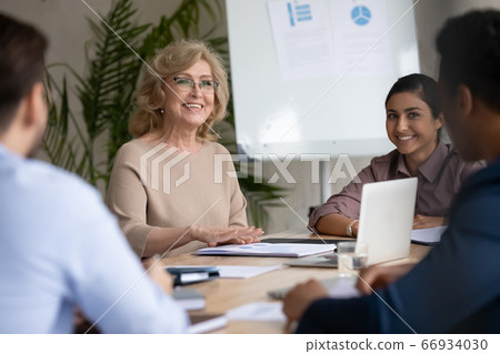 Smiling middle aged team leader speaking at corporate meeting 66934030