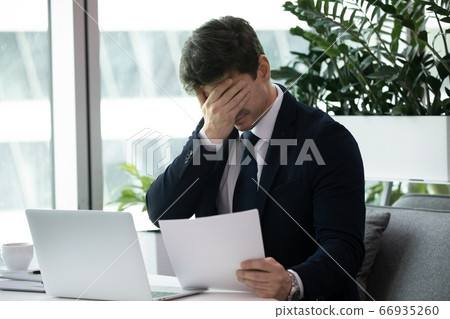 Frustrated sad business man got fired or bunkruptcy notification Frustrated sad business man got fired or bunkruptcy notification 66935260