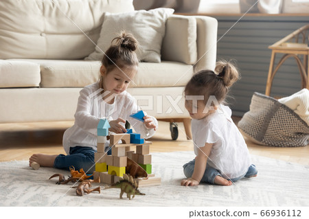 Two cute little girls playing on warm floor together Two cute little girls playing on warm floor together 66936112