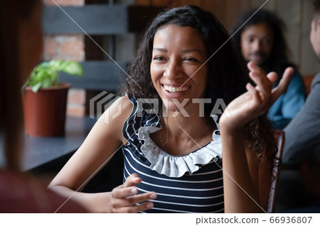 Indoor gather people focus on African woman talking with friend Indoor gather people focus on African woman talking with friend 66936807