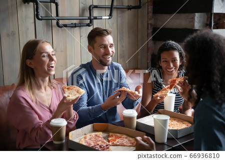 Four multiethnic best friends eat pizza drink coffee in cafe Four multiethnic best friends eat pizza drink coffee in cafe 66936810