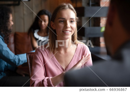 Woman participating in speed dating chatting with guy in cafe 66936867