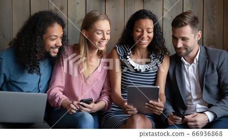 African woman showing funny video to friends using tablet device African woman showing funny video to friends using tablet device 66936868