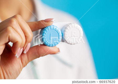 Vision problems, close up of woman holding container with contact lenses Vision problems, close up of woman holding container with contact lenses 66937620