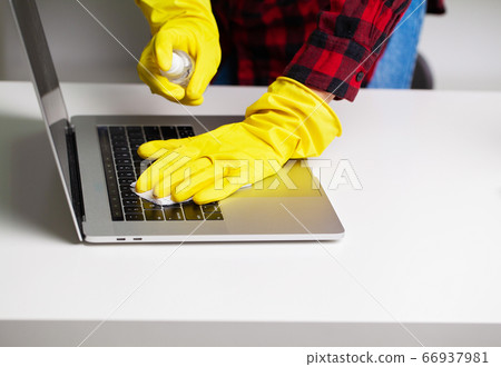 Close up of cleaner in yellow gloves wipes dust in the office Close up of cleaner in yellow gloves wipes dust in the office 66937981
