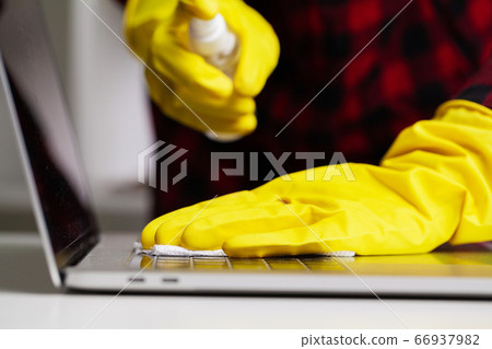 Close up of cleaner in yellow gloves wipes dust in the office Close up of cleaner in yellow gloves wipes dust in the office 66937982