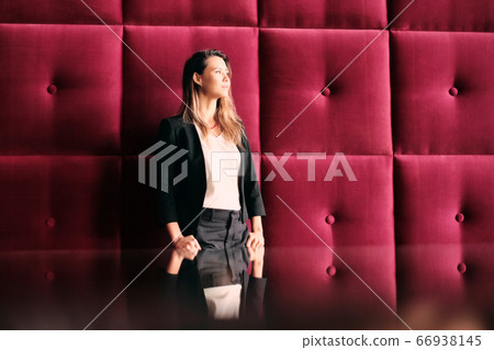 Contemplative Young Business Woman Leaning On Office Wall Contemplative Young Business Woman Leaning On Office Wall 66938145