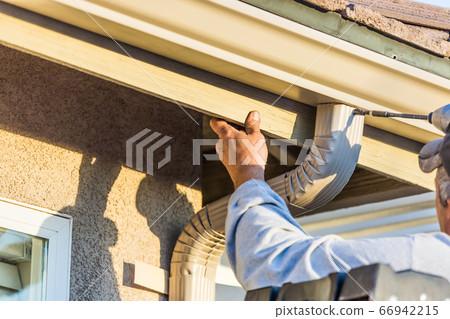 Worker Attaching Aluminum Rain Gutter and Down Spout 66942215