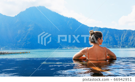 Happy woman relaxing in Batur volcano hot spring 66942951