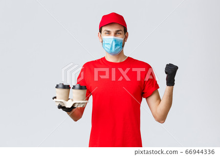 Takeaway, food and groceries delivery, covid-19 contactless orders concept. Cheerful courier in red uniform, gloves and face mask, holding client order coffee and fist pump in celebration Takeaway, food and groceries delivery, covid-19 contactless orders concept. Cheerful courier in red uniform, gloves and face mask, holding client order coffee and fist pump in celebration 66944336