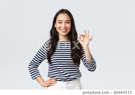 Lifestyle, beauty and fashion, people emotions concept. Satisfied good-looking female guarantee quality of product, recommend advertisement, showing okay sign, say no problem, all good 66944513