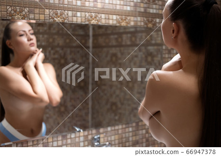 Unrecognizable naked female in bathroom 66947378