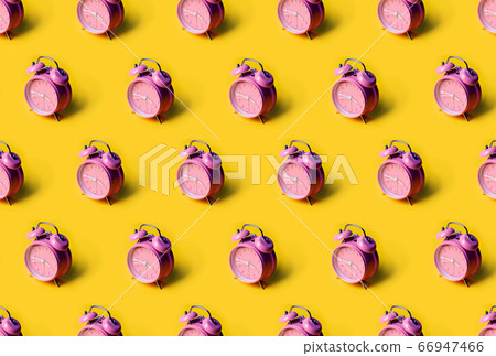Creative layout of pink alarm clock's on pastel yellow background. Minimal concept. Creative layout of pink alarm clock's on pastel yellow background. Minimal concept. 66947466