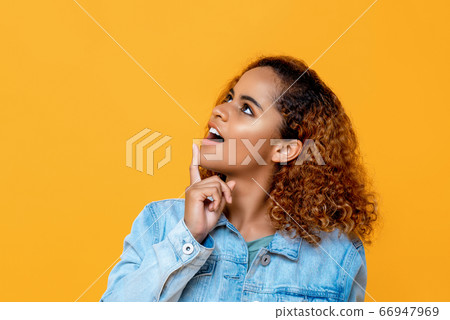 African American woman looking up while touching her chin African American woman looking up while touching her chin 66947969