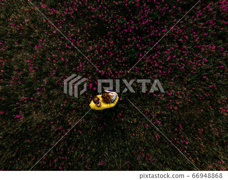 Woman and man sitting on green grass in park Woman and man sitting on green grass in park 66948868