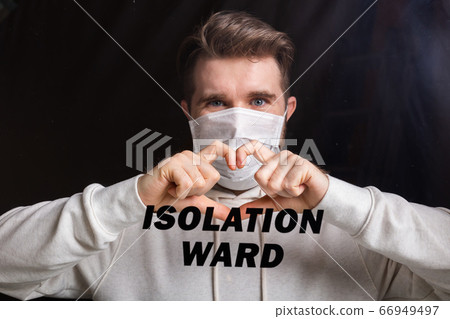 Man in medical mask showing heart gesture. Guy misses his family isolated in hospital. Stop coronavirus or covid-19 and the pandemic. Stay home. Quarantine concept. 66949497