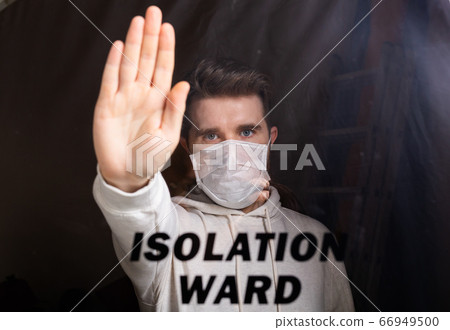 Man in respiratory mask showing stop gesture. Guy show stop gesture. Stop coronavirus or covid-19 and the pandemic. Stay home. Quarantine and isolation ward concept. Man in respiratory mask showing stop gesture. Guy show stop gesture. Stop coronavirus or covid-19 and the pandemic. Stay home. Quarantine and isolation ward concept. 66949500