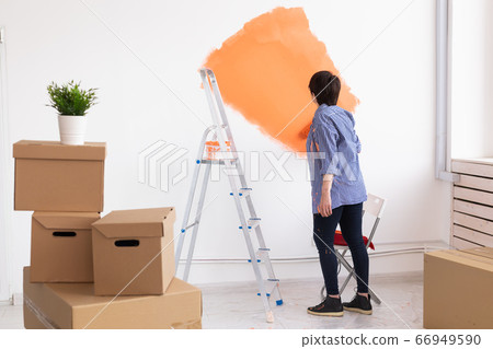 Renovation, redecoration and repair concept - middle-aged woman painting wall in new home. 66949590