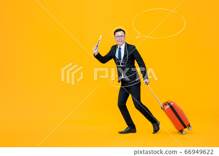 Smiling young Asian businessman holding luggage 66949622