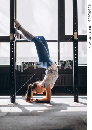 Portrait of attractive young woman doing yoga or pilates exercise Portrait of attractive young woman doing yoga or pilates exercise 66950696