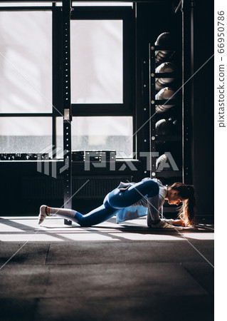 Portrait of attractive young woman doing yoga or pilates exercise Portrait of attractive young woman doing yoga or pilates exercise 66950786