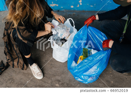 Two young women sorting garbage. Concept of recycling. Zero waste 66952019