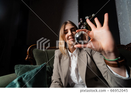 Woman in business suit holding crystal ball Woman in business suit holding crystal ball 66952045