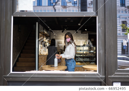 Woman using sanitizer gel cleans hands of coronavirus virus at cafe. Woman using sanitizer gel cleans hands of coronavirus virus at cafe. 66952495