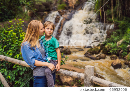 Mom and son on the background of Majestic landscape of waterfall in summer at Dalat, Vietnam 66952906