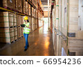 Caucasian female warehouse worker checking the 66954236