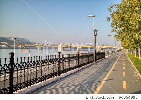 Sidewalk along Danube river with view to Margaret Bridge, Budapest. Sidewalk along Danube river with view to Margaret Bridge, Budapest. 66954983