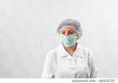 Tired female medic, nurse in protective equipment and a mask from viruses, on a white background. Tired female medic, nurse in protective equipment and a mask from viruses, on a white background. 66958787