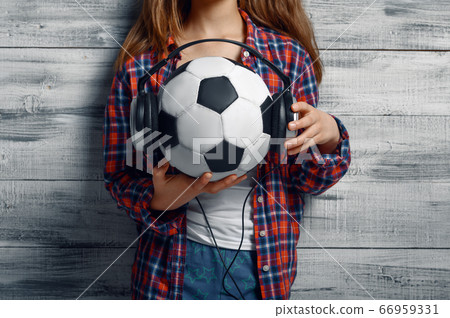 Little girl puts headphones on ball in studio Little girl puts headphones on ball in studio 66959331
