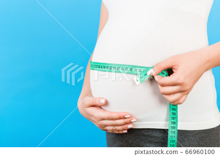 Close up image of tape measure on pregnant woman's Close up image of tape measure on pregnant woman's 66960100