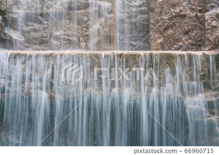 landscape of beautiful Artificial waterfall in garden at the public park. 66960715