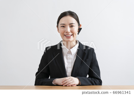 A young woman in a suit wearing a headset and talking from the camera's perspective 66961341