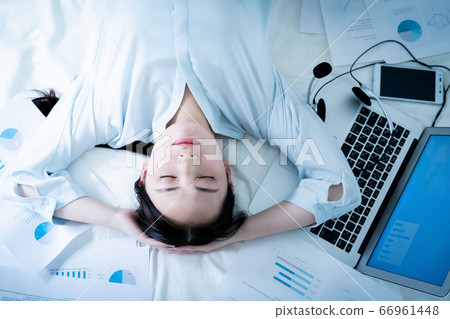 Woman lying in bed tired of telework Woman lying in bed tired of telework 66961448