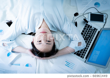 Woman lying in bed tired of telework Woman lying in bed tired of telework 66961449