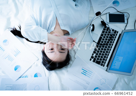Woman lying in bed tired of telework Woman lying in bed tired of telework 66961452