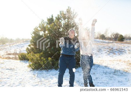Loving couple play snowballs in winter in the 66961543