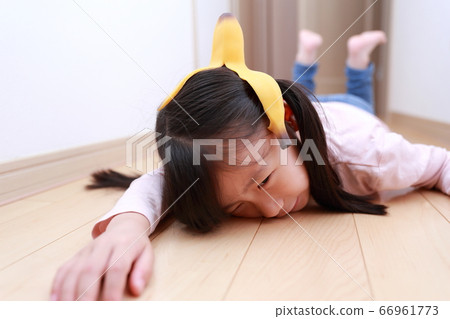 A girl who fell down on the banana skin that fell on the floor 66961773